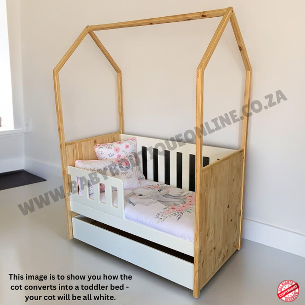 TentLargeCot-White Wooden toddler bed with white mattress and floral bedding in a room setting.