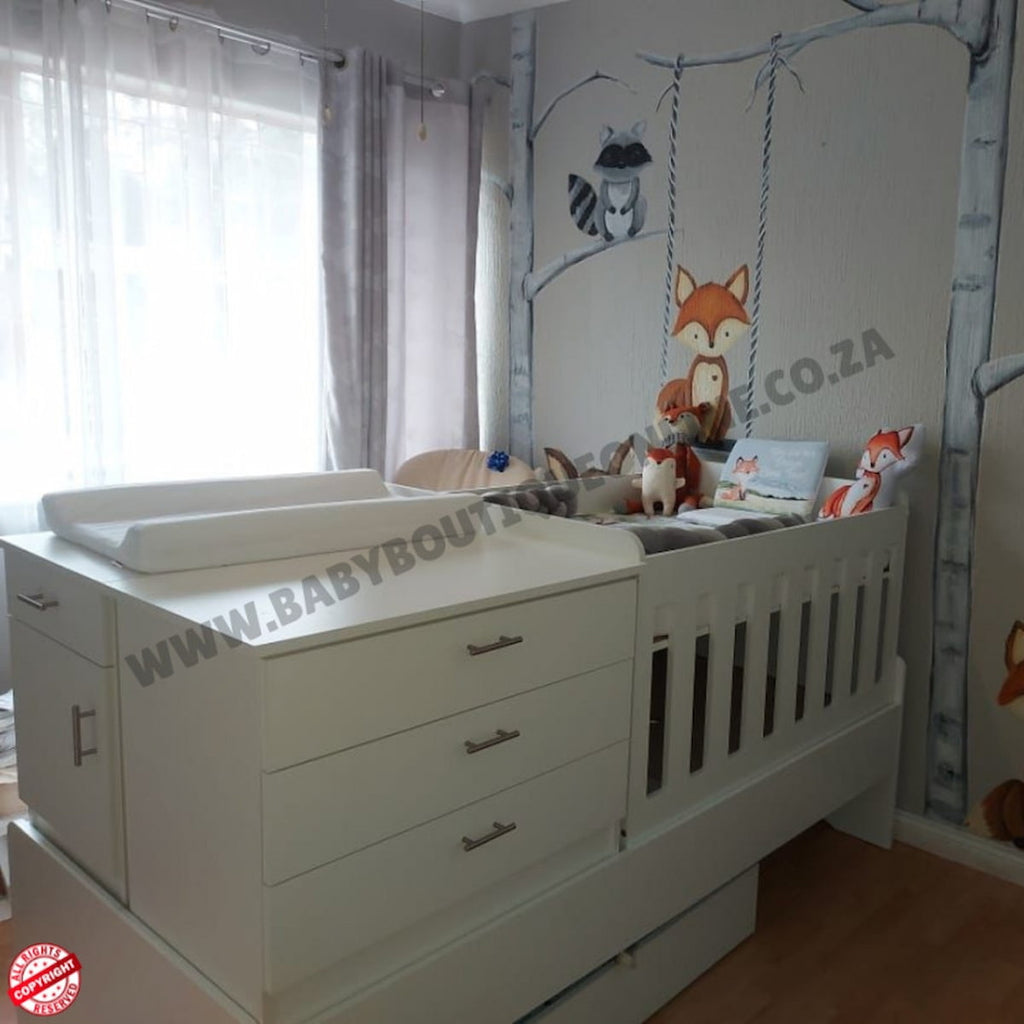 Bedroominabox-5-in-1Cot White baby crib with changing table in a nursery with wall art and curtains.