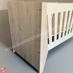 Emma Large Wooden Cot-White_NordicIce White crib with floral bedding on a wooden floor