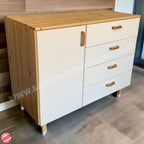 Wooden cabinet with white doors and drawers in a room setting