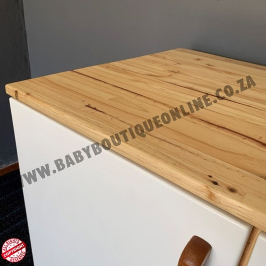 Wooden surface with 'www.babyboutiqueonline.co.za' branding on a white cabinet.