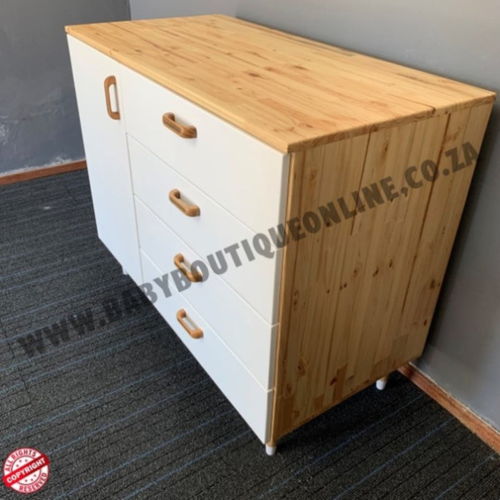 Wooden dresser with white base and wooden top on a gray floor.