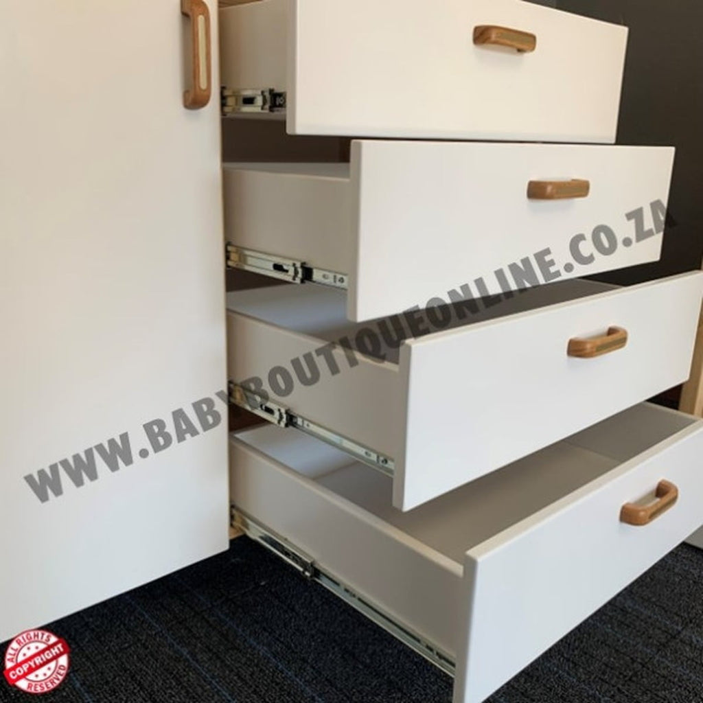 White drawers with wooden handles on a black floor, featuring a website URL.