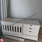 BedroominaBox-5in1Cot White crib with drawers against a gray wall