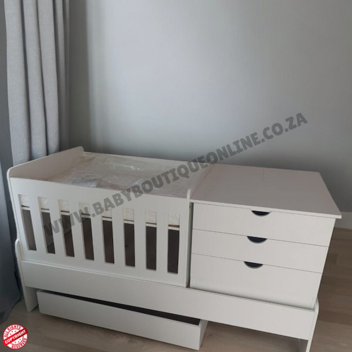 BedroominaBox-5in1Cot White crib with drawers against a gray wall