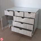 Wooden dresser with multiple drawers on a plain floor.