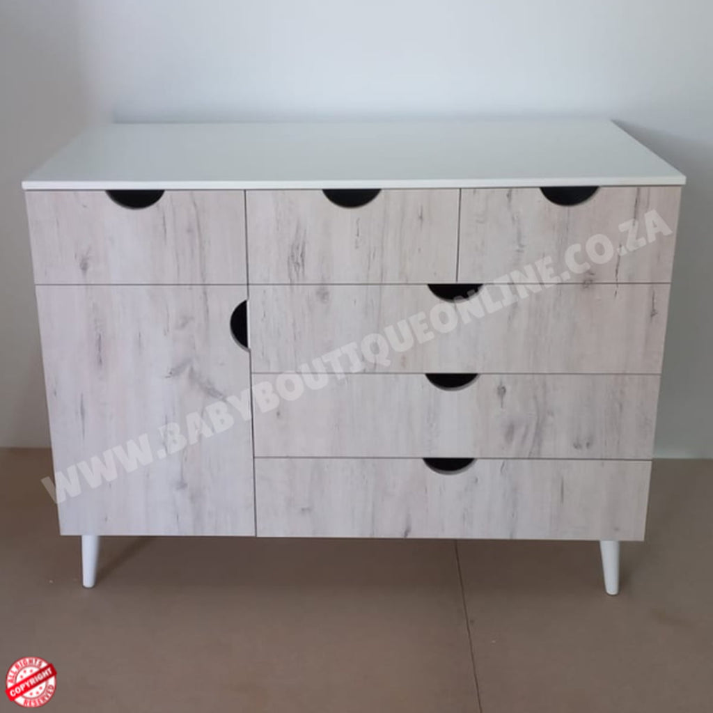 Wooden dresser with white top and black handles on a plain background