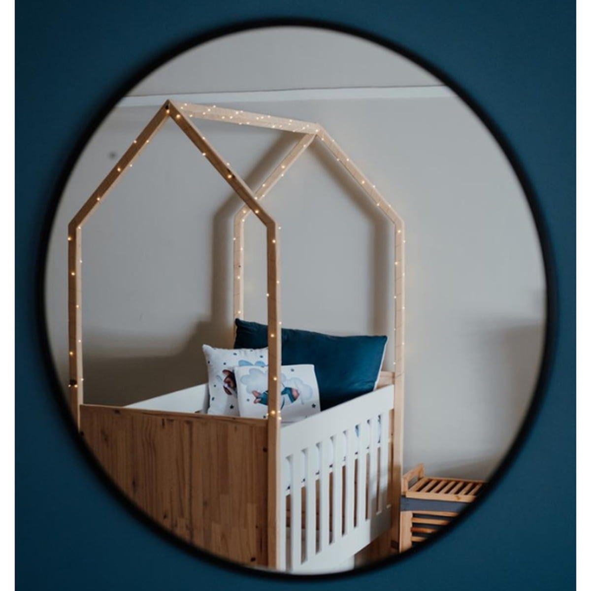 Tent Large Cot-White_OakSmoke with a house-shaped canopy and string lights, reflected in a circular mirror.