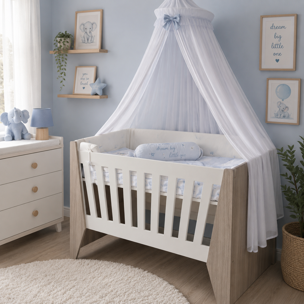 A white and light wood baby crib with a white canopy bedspread and matching pillow in a styled nursery room with blue walls, wooden shelves, and framed elephant prints.