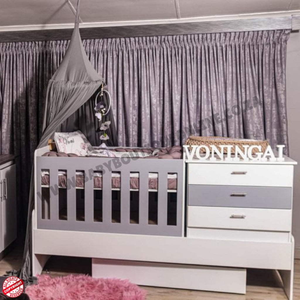 BabyBedroominaBox5-in-1Cot Nursery room with crib, changing table, and decorative elements.