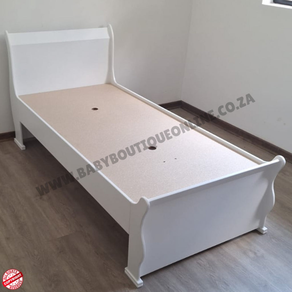 BabyBedroominabox5-in-1SleighCot White bed frame on a wooden floor with a visible brand logo.