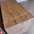 Wooden table with visible grain and texture on a tiled floor.