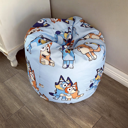 A round beanbag chair with a printed design featuring cartoon characters on a blue background.