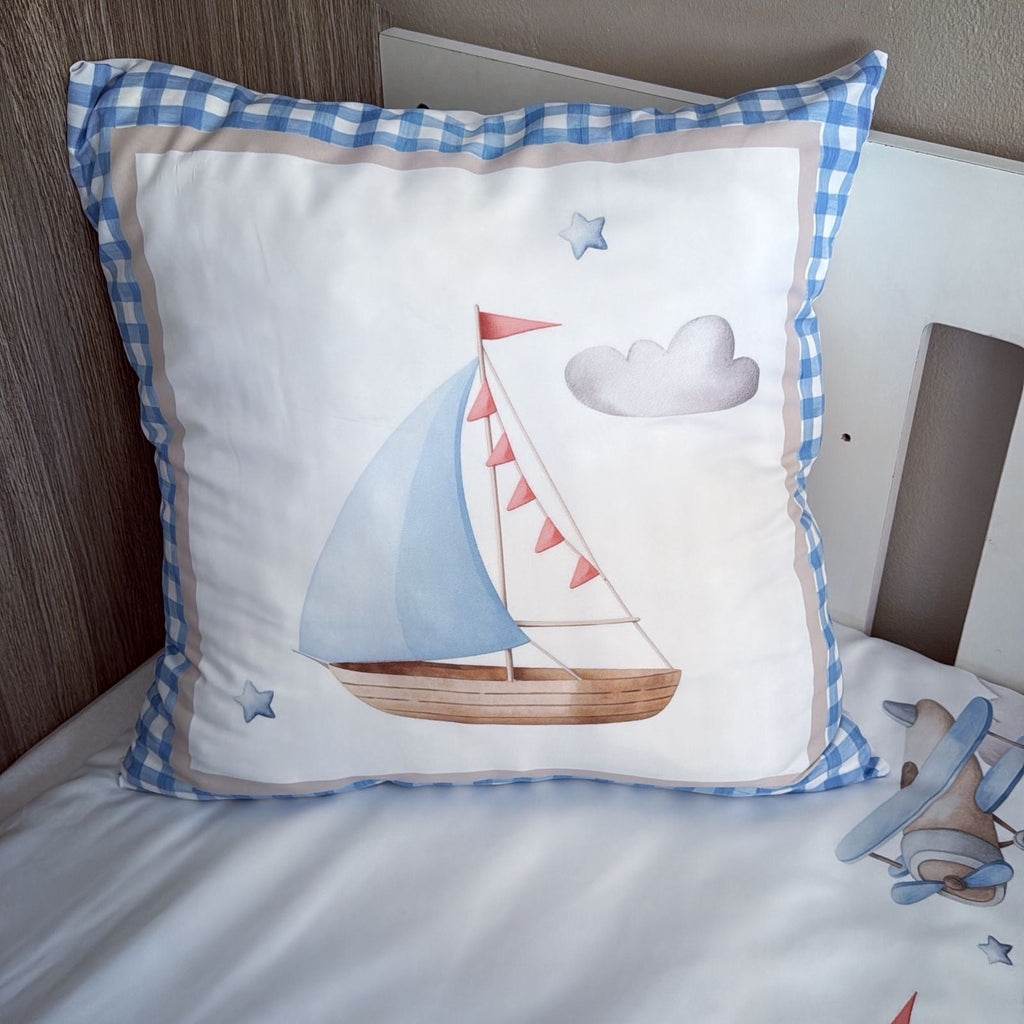 Decorative pillow with sailboat design on a bed