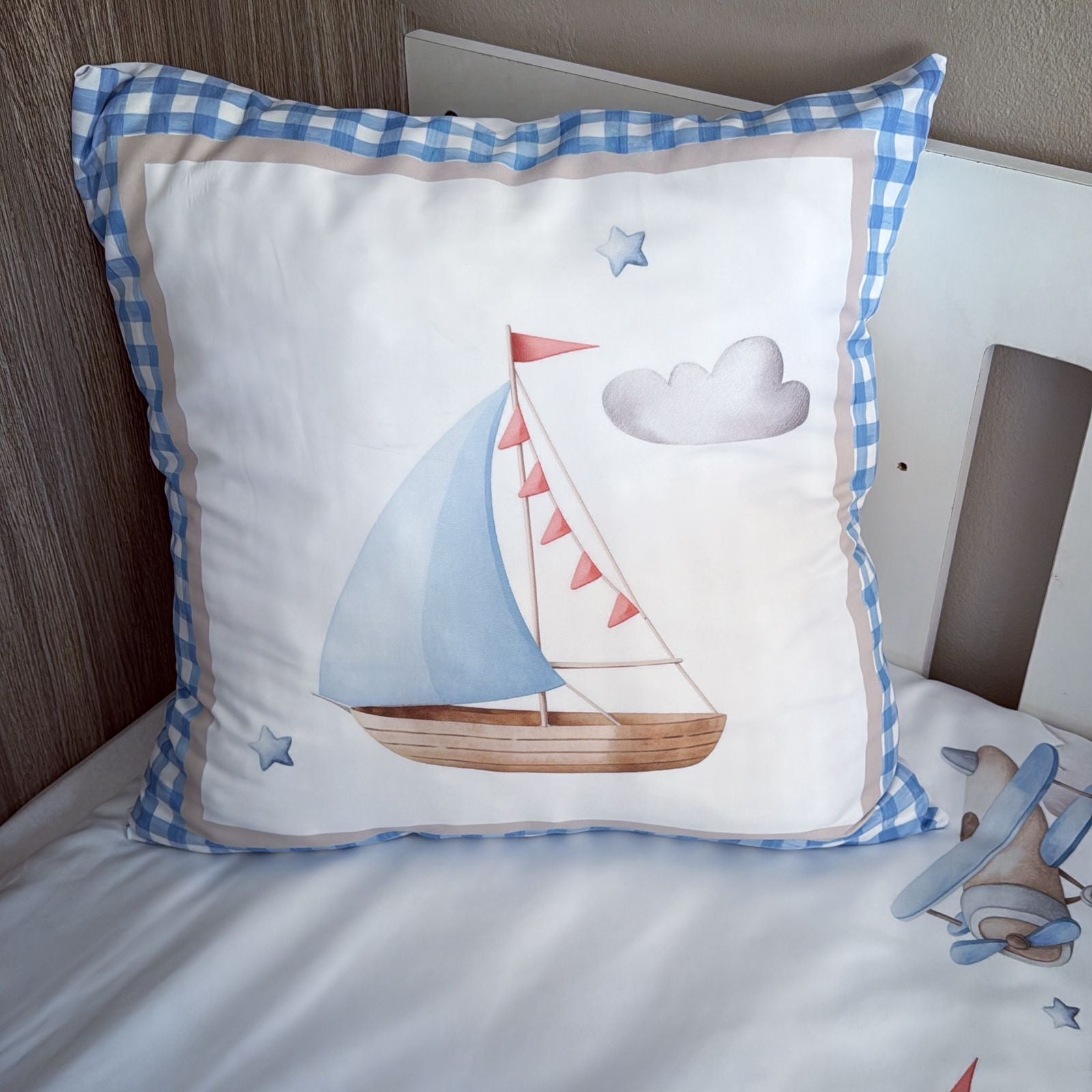 Decorative pillow with sailboat design on a bed