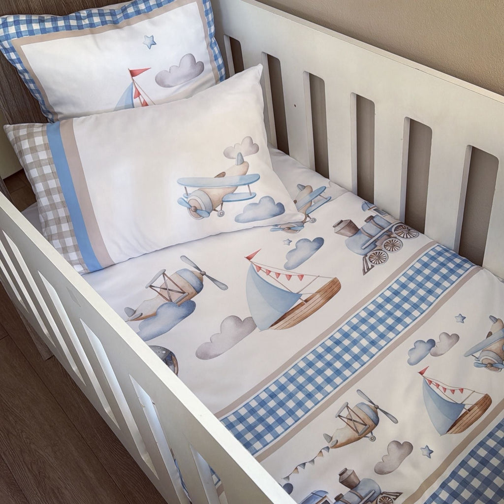Baby crib with airplane and sailboat patterned bedding