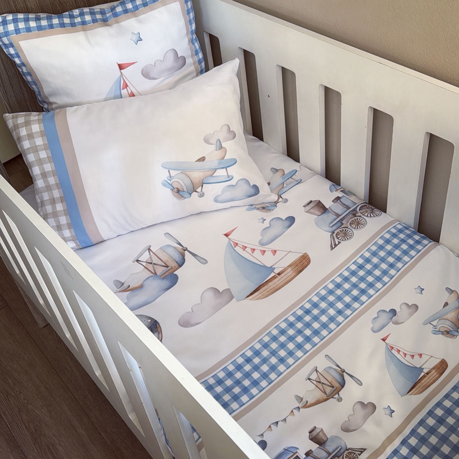 Baby crib with airplane and sailboat patterned bedding