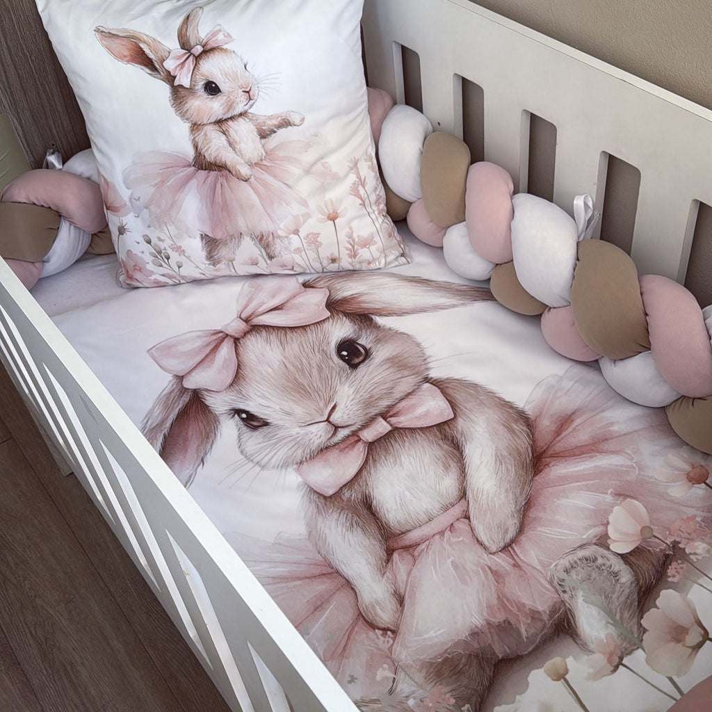 Crib with bunny-themed bedding and decorative pillows