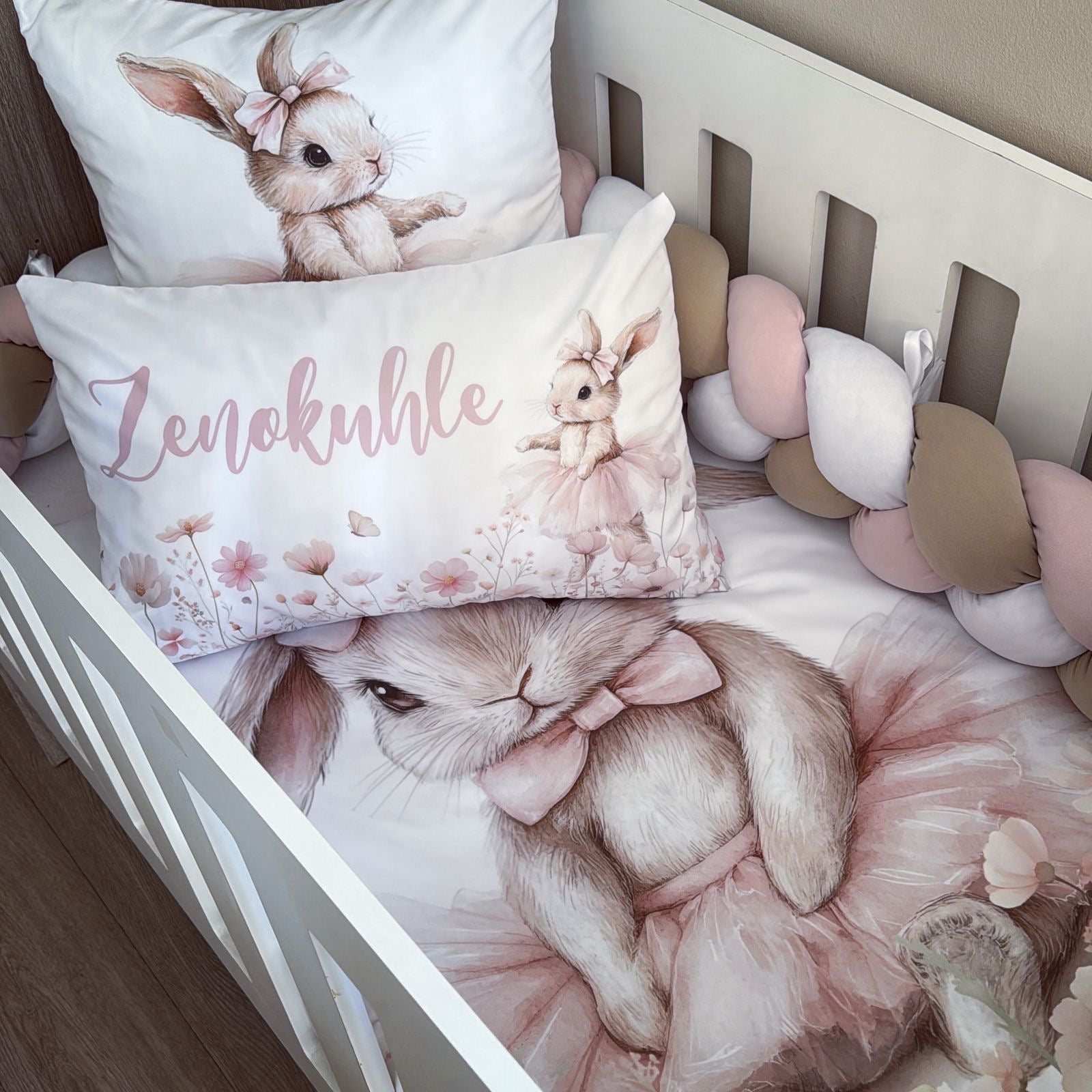 Crib with decorative pillows featuring bunny designs and the brand 'Lenokuhle'.