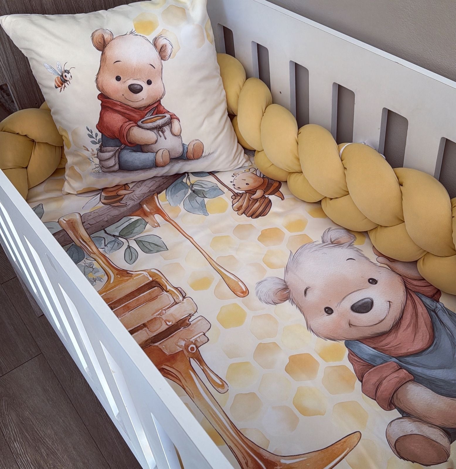 Baby crib with Winnie the Pooh-themed bedding and pillow