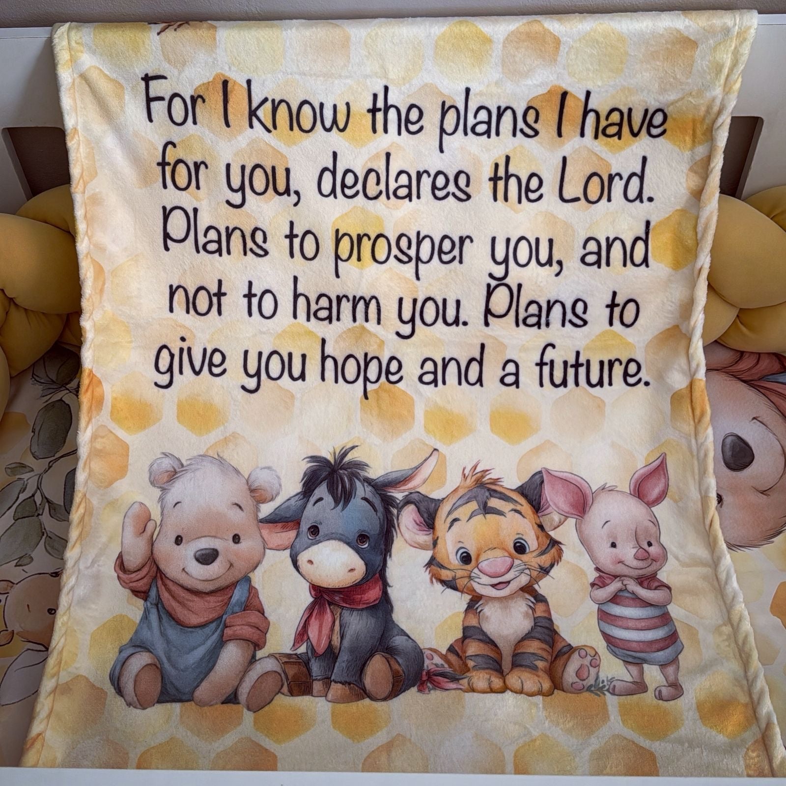 Blanket with cartoon characters and inspirational text on a yellow and brown patterned background