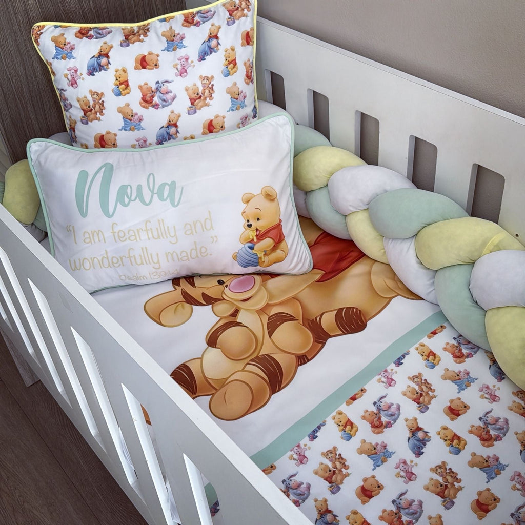 Crib with Winnie the Pooh-themed bedding and pillows.