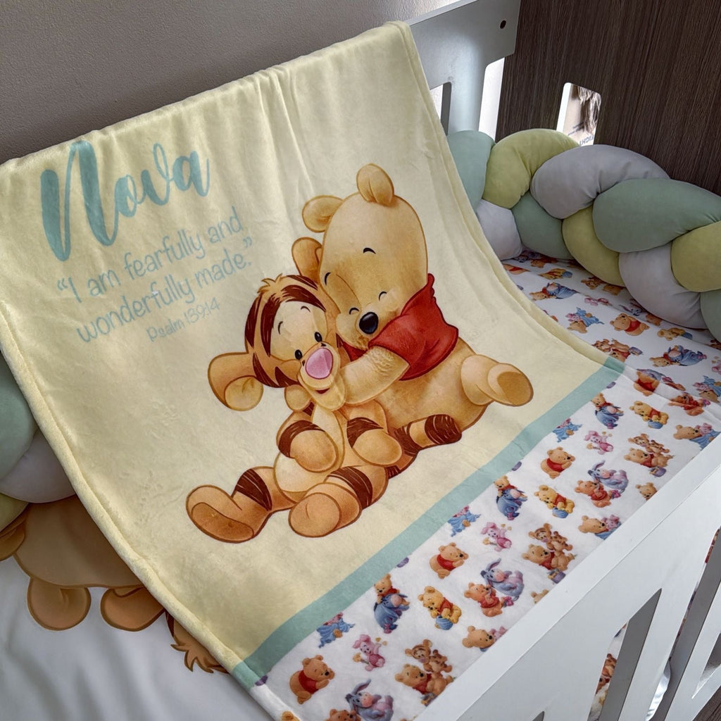 Baby crib with Winnie the Pooh and Tigger blanket and bedding.