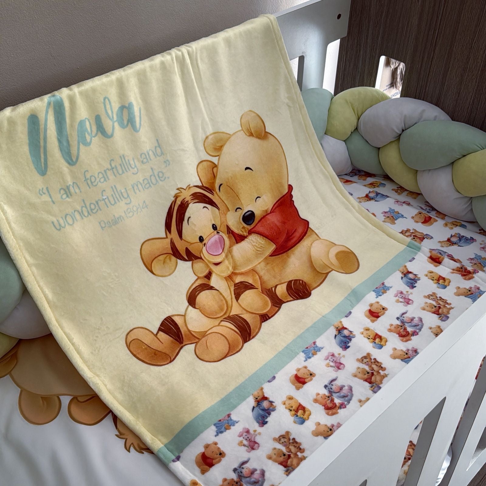 Baby crib with Winnie the Pooh and Tigger blanket and bedding.