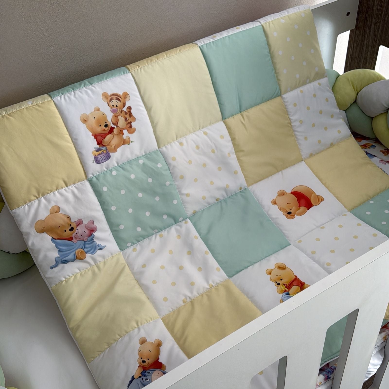 Patchwork quilt with cartoon bear designs on a crib