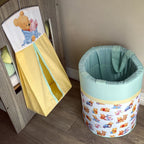 Children's toy storage bin with cartoon design on a wooden floor.