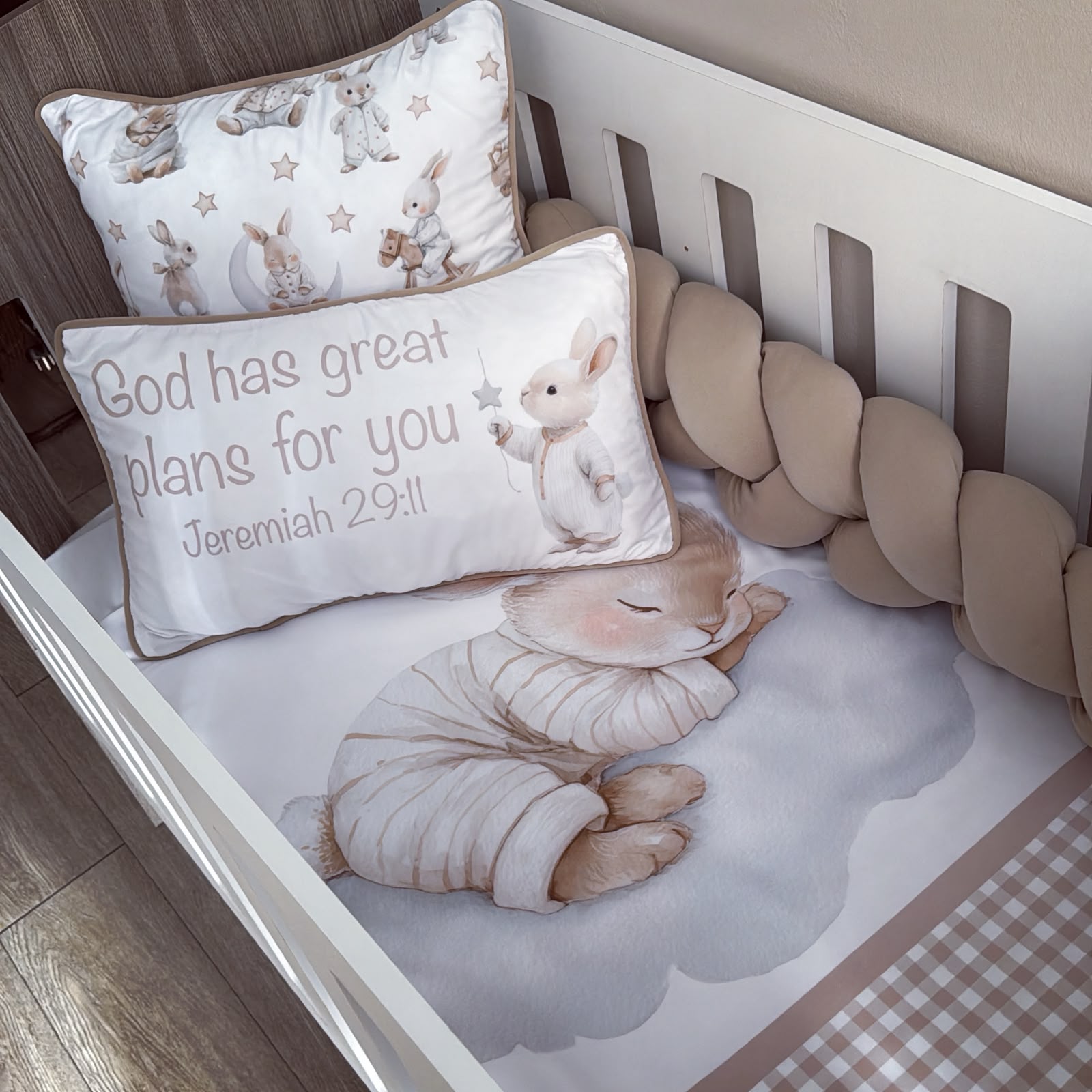 A baby crib bedding set featuring a white crib bumper, a matching crib sheet, and two decorative pillows with bunny illustrations and the text 'God has great plans for you Jeremiah 29:11'.