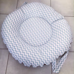 Round cushion with chevron pattern on a tiled floor