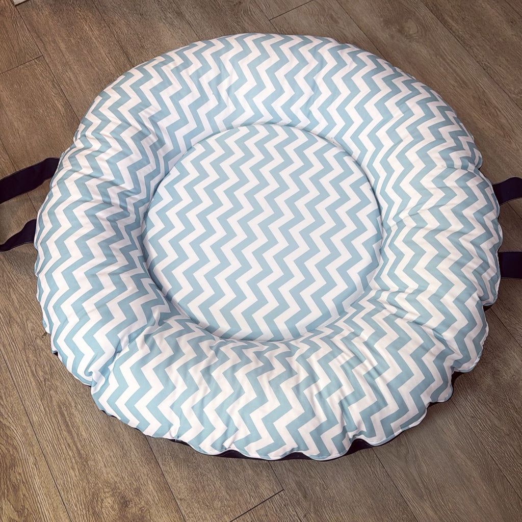 Round baby doughnut with blue and white zigzag pattern on a wooden floor