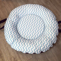 Round baby doughnut with blue and white zigzag pattern on a wooden floor