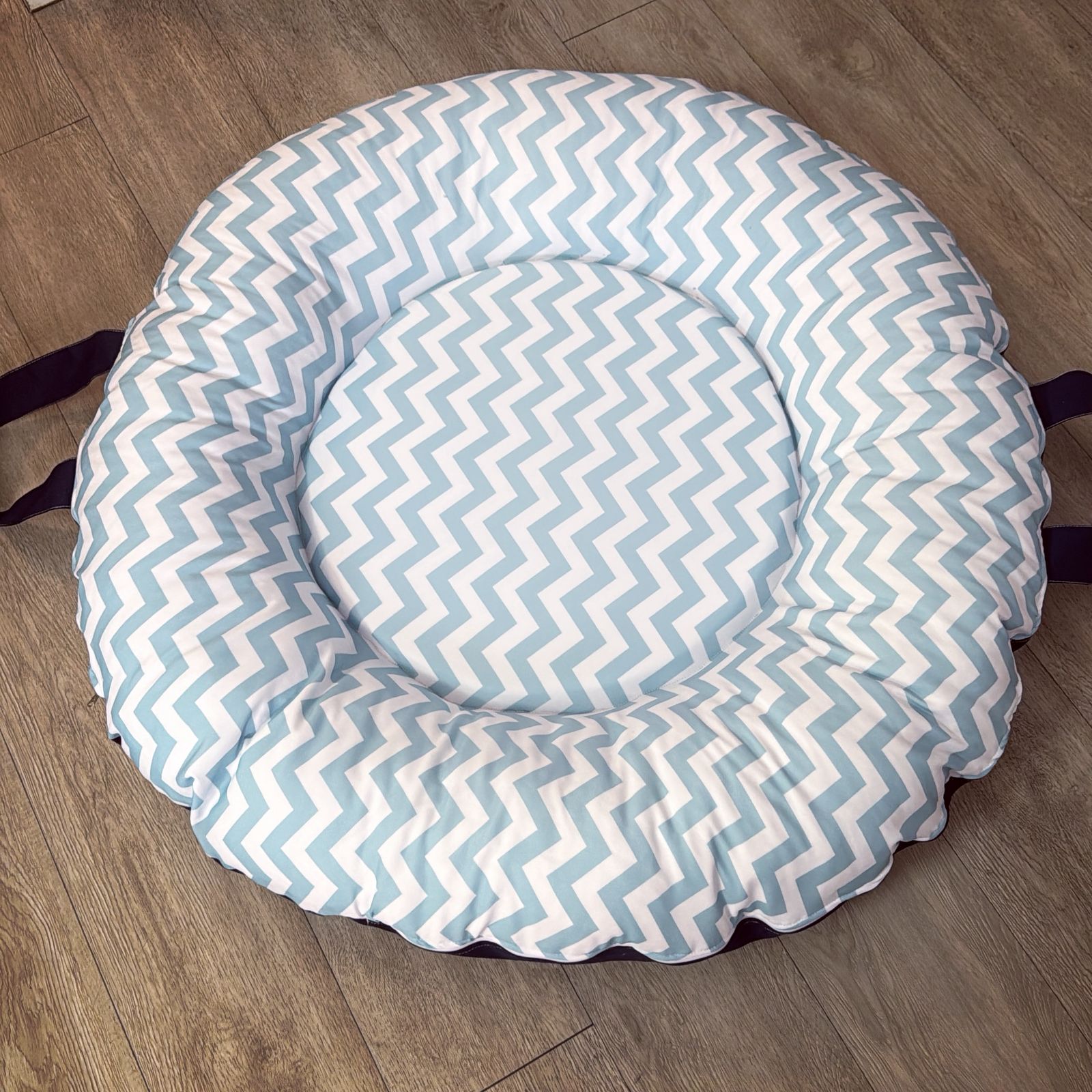 Round baby doughnut with blue and white zigzag pattern on a wooden floor