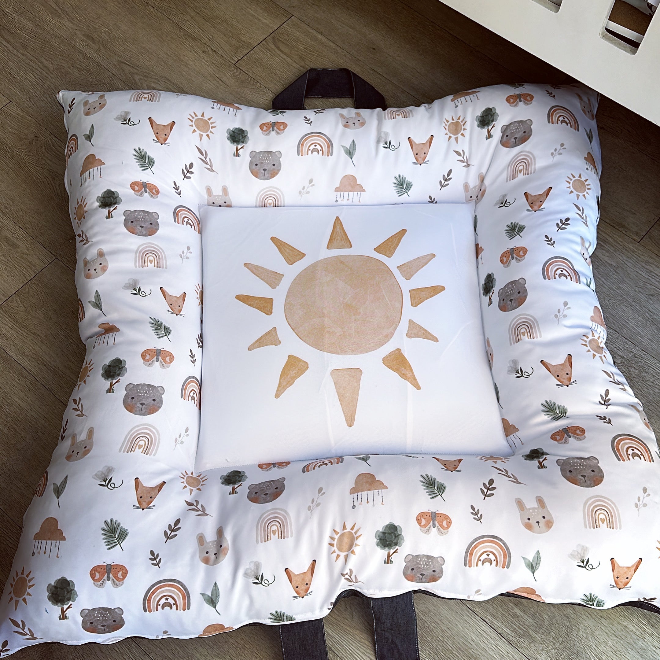 A play doughnut with a boho sun design and various playful patterns, including animals and rainbows, with a white background.