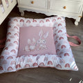 A soft play doughnut for babies with a pink center featuring a cute character, surrounded by a pattern of rainbows and bunnies in a grey and blue color scheme.
