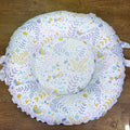 Round baby play mat with floral and bird pattern on a wooden floor