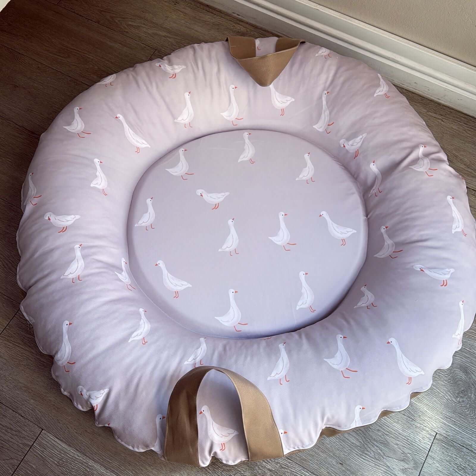 Round Doughnut - Goose 01 cushion with duck pattern on a wooden floor
