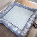 A gray baby play doughnut with a washable cover, featuring a pattern of sea creatures and stars on a light blue background.