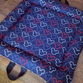 A soft play doughnut with a Mickey Mouse pattern in blue, red, and black, featuring a carry handle.