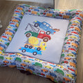 A colorful baby play doughnut with a transportation theme, featuring various vehicles such as cars, trucks, and trains in a patterned design.