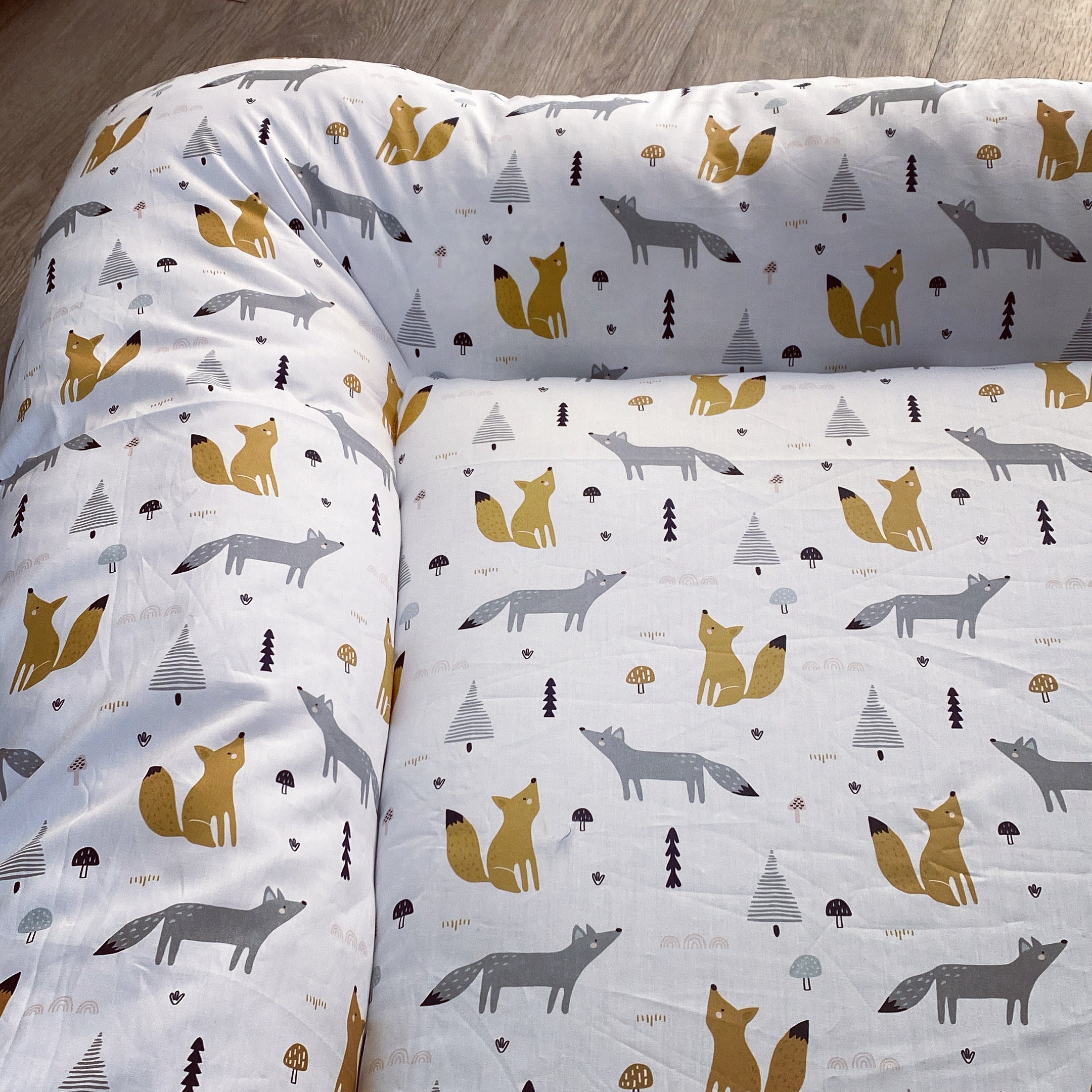 Baby Doughnut - Woodlands 01with fox pattern on a wooden floor