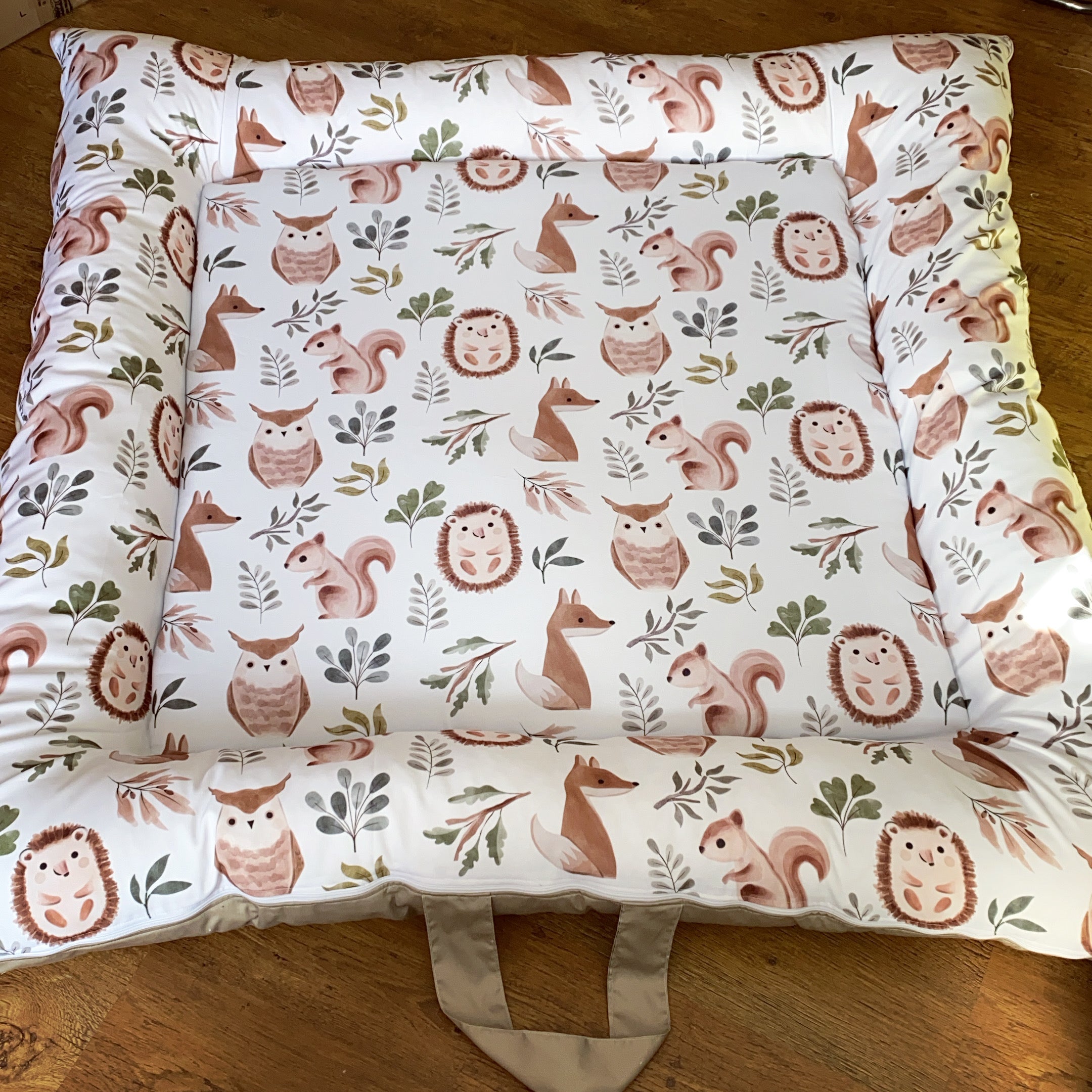 Baby Doughnut - Woodlands 02 with forest animal pattern on a wooden floor