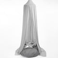 A grey hanging tent canopy with a hoop diameter of 45cm, displayed outdoors. It appears to be made of a stretchy fabric and is draped elegantly with one side featuring a metallic ornament.