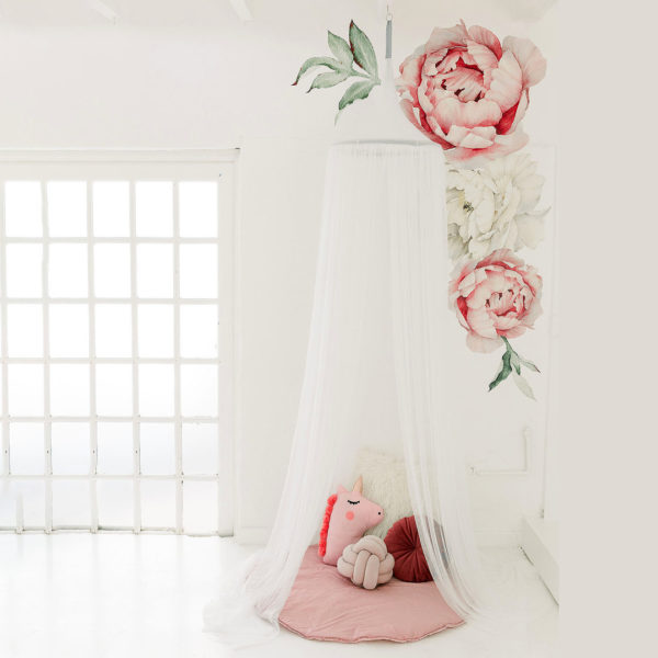 A white hanging tent canopy with a floral design, set up in a room with a window and a pink teddy bear underneath.