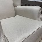 Close-up of a light gray upholstered chair with a cushioned seat.