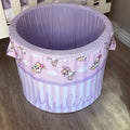 A large, round laundry basket with a purple base and a bunny-themed design, featuring cartoon images of bunnies and the name 'Mulisa' printed on the side.