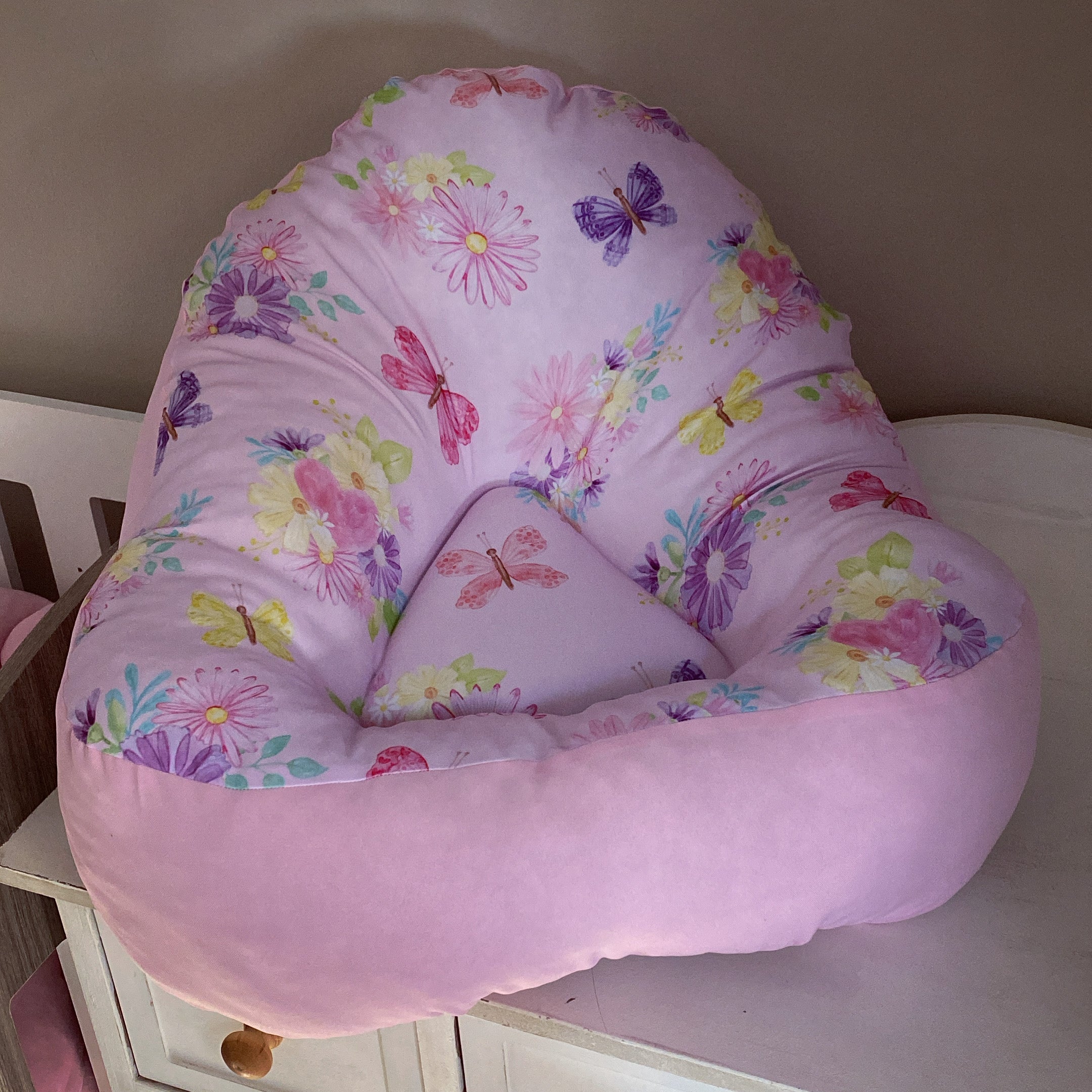 A pink lounger with a floral butterfly pattern, designed for comfort and style.