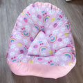Pink baby seat with floral and rainbow patterns on a wooden floor